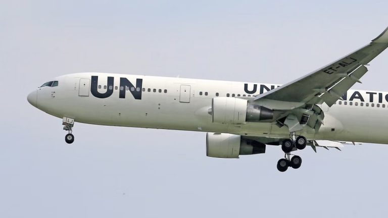 Close-up of a United Nations airplane in flight, showing detailed landing gear.